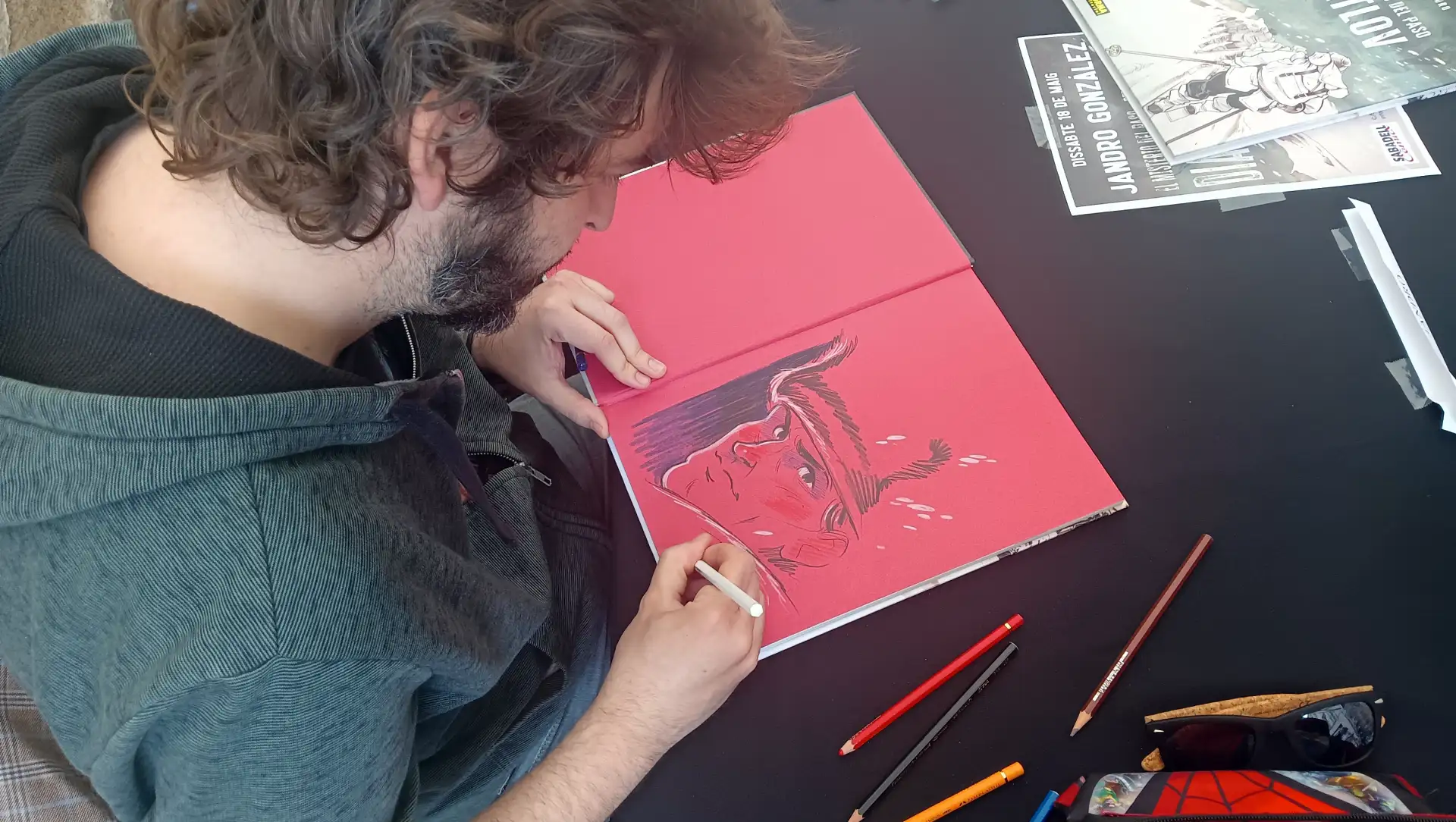 Jandro González, dibujante de El misterio del paso Diátlov firmando un ejemplar en Sabadell Comics